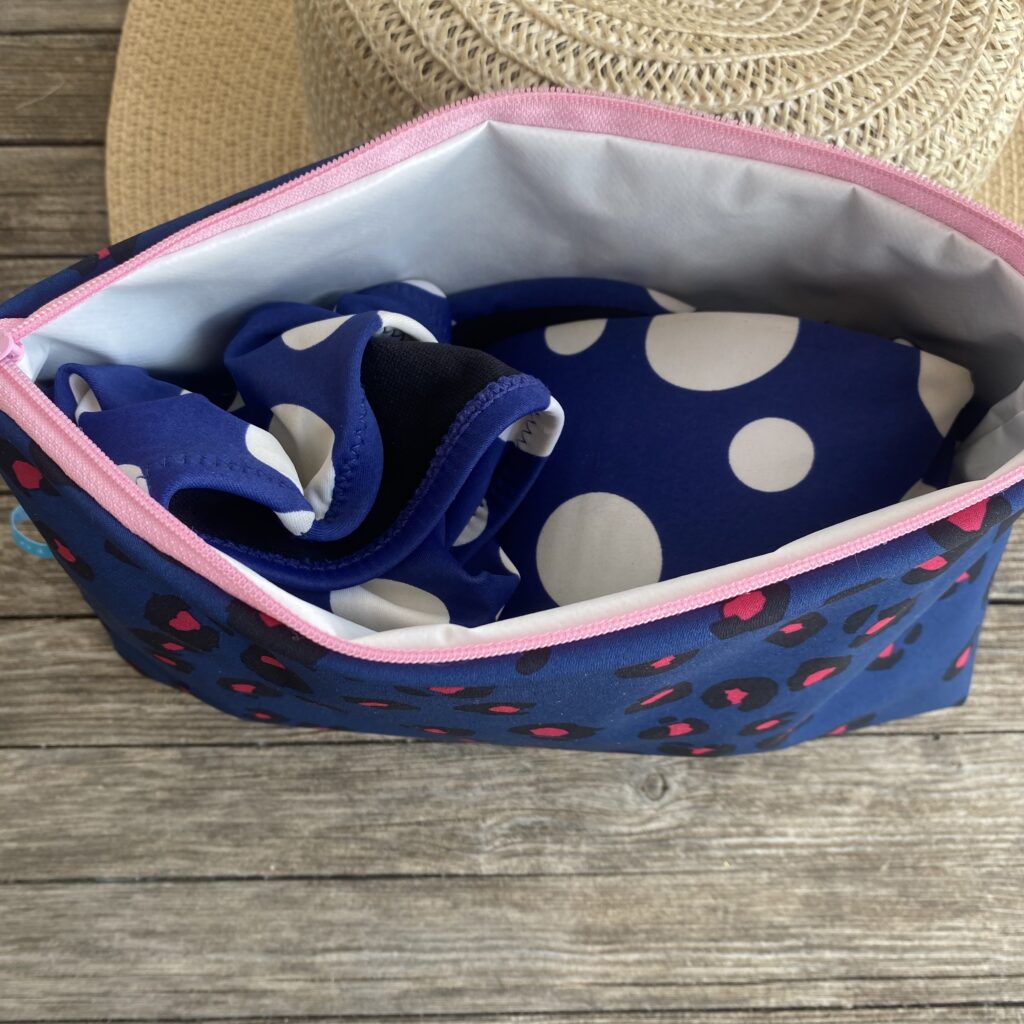Wetbag, Schwimmtasche, Nasstasche aus Softshell für Strand oder Schwimmbad, Leomuster dunkelblau/ pink, geöffnet mit Bikini innen