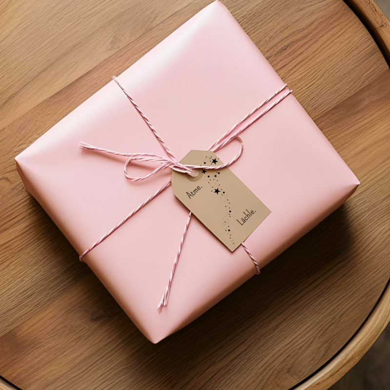 Achtsame Geschenkanhaenger an rosa Paket