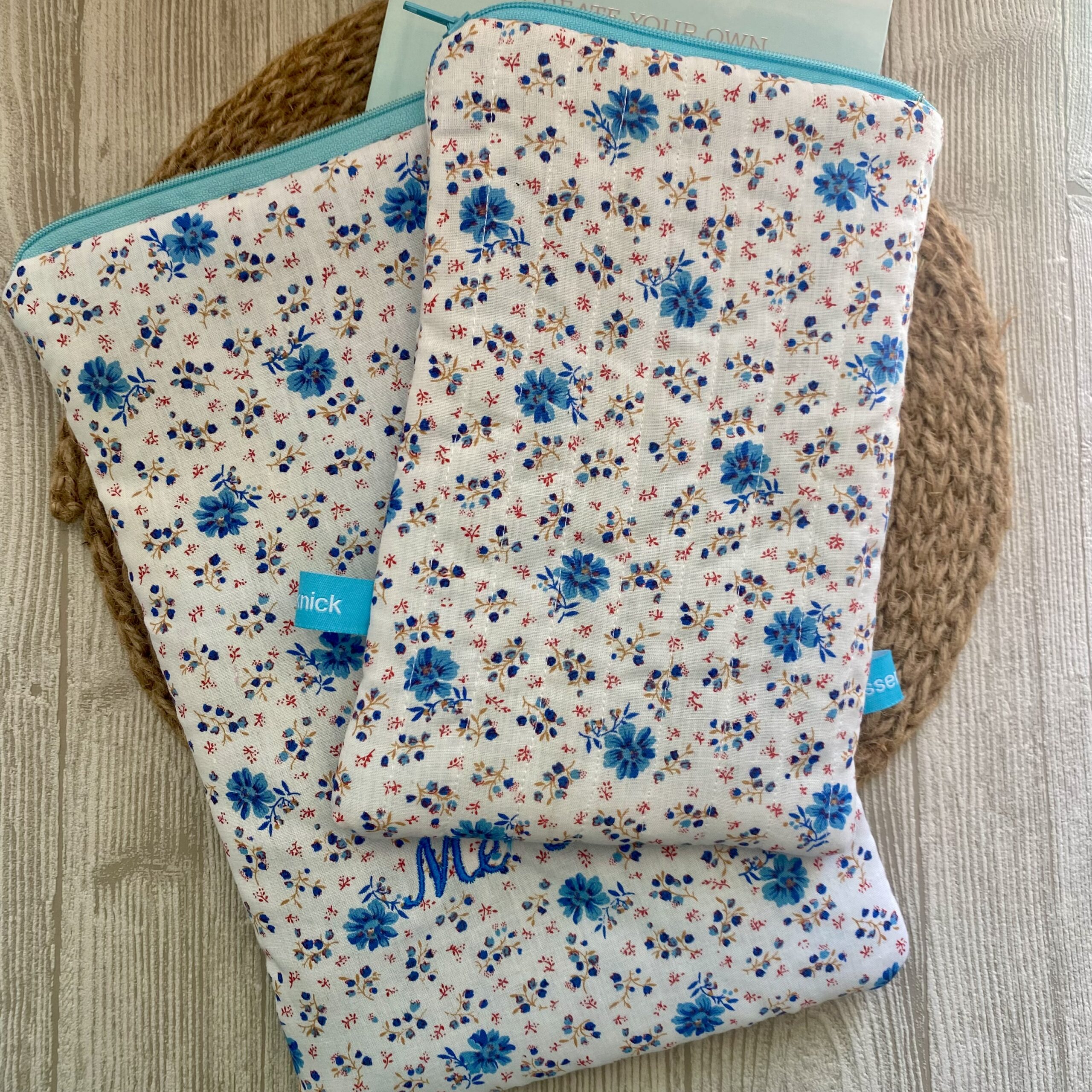 Personalisierbare Buchtasche mit kleinen Blümchen, Bücherschlafsack, Buchhülle Streublumen, gesteppt, bestickt,weiß/ türkis